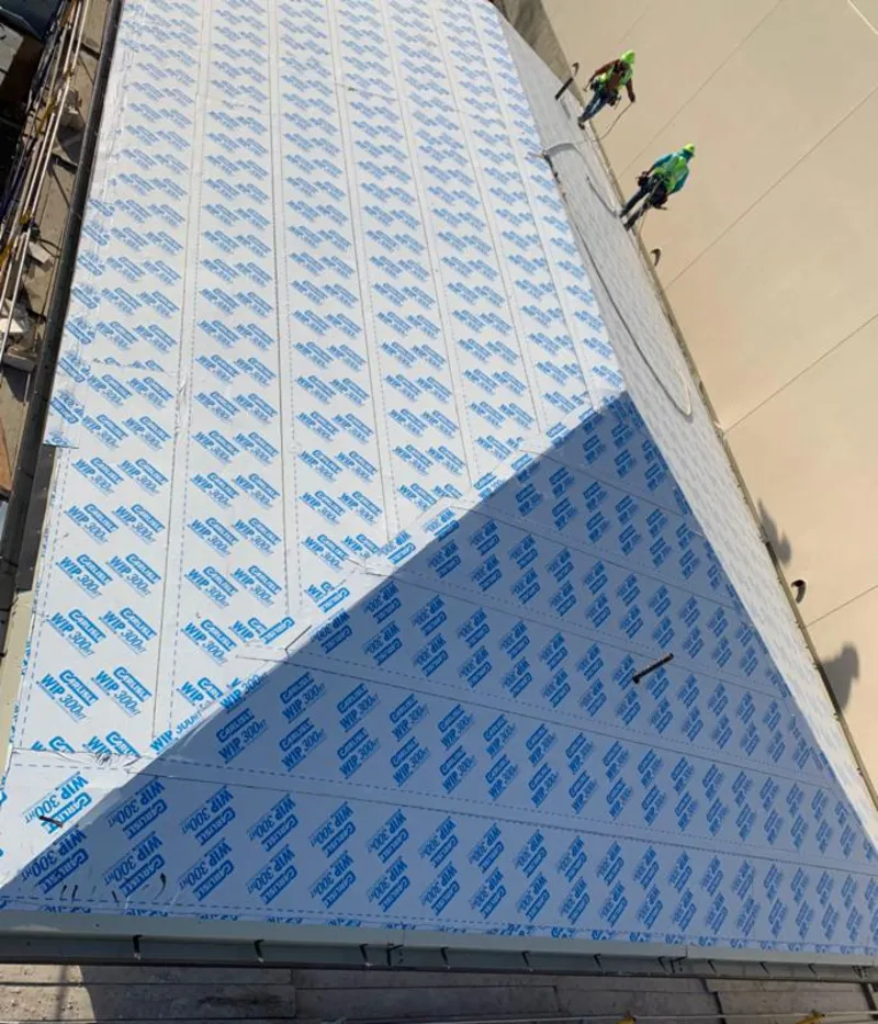 Professional roofers installing underlayment on a metal roof in Broadalbin